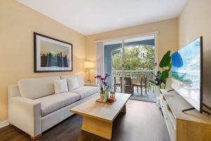 un soggiorno con divano bianco e tavolo di Dharma Home Suites South Miami at Red Road Commons a Miami