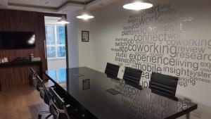 a conference room with a wall with writing on it at Lindo studio na área central de Poços in Poços de Caldas