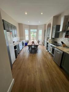 a large kitchen with a table in the middle of it at Grand Tulse Hill Villa in London