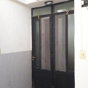 un par de puertas negras en un baño en EL ZAGUAN ANEXO I en Cafayate