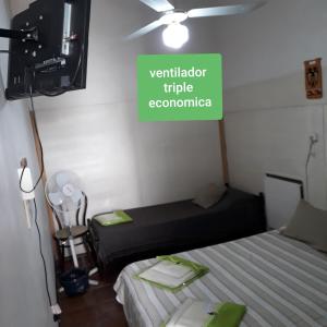 a room with two beds and a sign on the wall at EL ZAGUAN ANEXO I in Cafayate