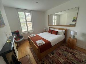 a bedroom with a large bed and a mirror at Grand Tulse Hill Villa in London