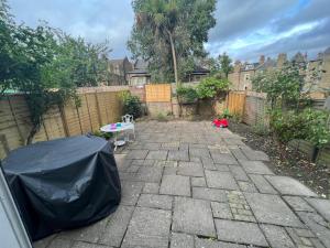 a patio with a black tarp in a backyard at Grand Tulse Hill Villa in London