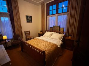 a bedroom with a bed and two windows at Villa Steenwyck Giethoorn in Steenwijk