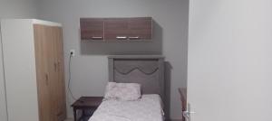 1 dormitorio con 1 cama, mesa y armarios en Pousada VIDA en Pelotas