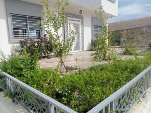 a house with a white fence and some plants at Appartement luxueux à louer à Taounate in Taounate