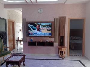 Appartement luxueux à louer à Taounate في تاونات: غرفة معيشة مع تلفزيون بشاشة مسطحة على جدار