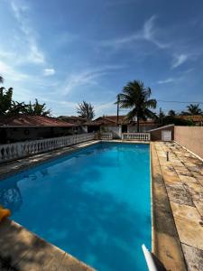 a large swimming pool with blue water at Casa em Saquarema in Saquarema