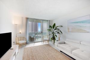 sala de estar con sofá blanco y TV en 3 BR Beach getaway Sunny Isles Ocean Reserve Miami en Sunny Isles Beach