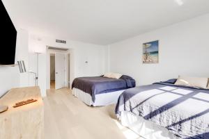 1 dormitorio con 2 camas y mesa en 3 BR Beach getaway Sunny Isles Ocean Reserve Miami, en Sunny Isles Beach