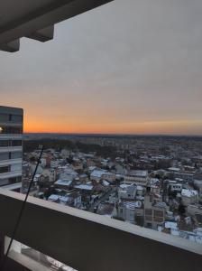 - une vue sur la ville au coucher du soleil depuis un bâtiment dans l'établissement Duplex with incredible view of Paris, à Bagnolet