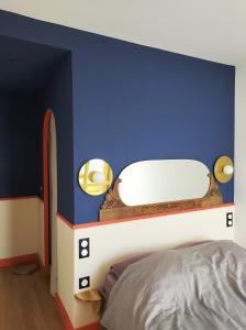 - une chambre avec un mur bleu et un lit dans l'établissement Duplex with incredible view of Paris, à Bagnolet