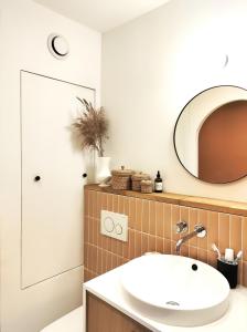 La salle de bains est pourvue d'un lavabo et d'un miroir. dans l'établissement Duplex with incredible view of Paris, à Bagnolet