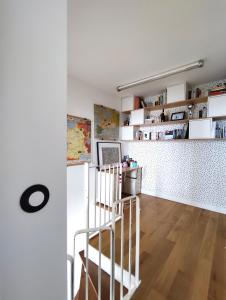 une cuisine blanche avec un escalier en colimaçon dans une pièce dans l'établissement Duplex with incredible view of Paris, à Bagnolet