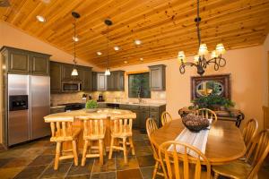 a kitchen with a wooden table and wooden chairs at St Bernard at Tahoe Donner Remodeled 3BR - Private Hot Tub and Gym and Pool Access in Truckee