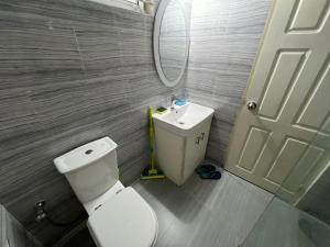 a bathroom with a toilet and a sink and a mirror at Alom Manzil - 4 Bedroom Family Home in Sylhet