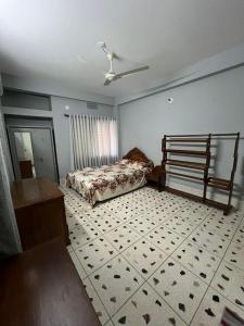 1 dormitorio con 1 cama y suelo de baldosa en Alom Manzil - 4 Bedroom Family Home en Sylhet
