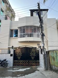 una casa blanca con una puerta negra y una valla en Alom Manzil - 4 Bedroom Family Home en Sylhet