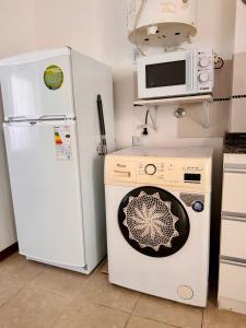 a kitchen with a washing machine and a microwave at Departamento Nórdico San Juan in San Juan