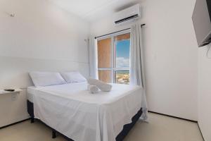 een slaapkamer met een wit bed en een raam bij Beach Townhouses #C14 - Aconchego por Carpediem in Aquiraz