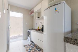 een keuken met witte kasten en een koelkast bij Beach Townhouses #C14 - Aconchego por Carpediem in Aquiraz
