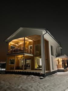 a large house with a large balcony in the snow at Villa Golden House in Rovaniemi