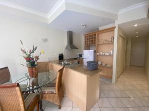 a kitchen with a glass table and a counter top at Lakes Resort 1 Bedroom Apartment in Edge Hill