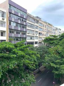 un gran edificio de apartamentos con árboles delante de él en Flat Ipanema com Garagem, en Río de Janeiro