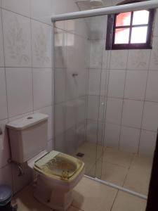 a bathroom with a toilet and a glass shower at Conforto e simplicidade! Casa top com garagem, cozinha, banheiro e quarto in Cabo Frio