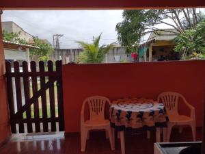 a table and chairs on a balcony with a fence at Conforto e simplicidade! Casa top com garagem, cozinha, banheiro e quarto in Cabo Frio