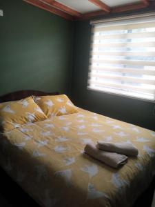 1 cama con 2 toallas en un dormitorio en Cabaña Gesell, en Puerto Natales