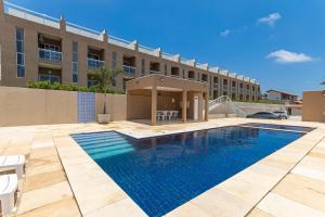 a swimming pool in front of a building at Beach Townhouses #C13 - Apartamento por Carpediem in Aquiraz