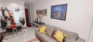 ein Wohnzimmer mit einem Sofa und einer Küche in der Unterkunft Quarto e banheiro privativos com garagem fechada em apartamento aconchegante em Jardim da Penha in Vitória