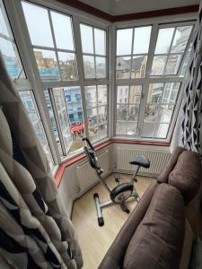 Zimmer mit Sofa und Stuhl vor den Fenstern in der Unterkunft The Rumah at Hyde Park in London