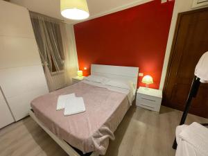ein Schlafzimmer mit einem Bett und einer roten Wand in der Unterkunft Harry's Canal View in Venedig