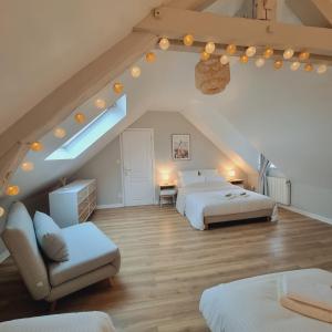 a attic bedroom with two beds and a couch at Gîte La Frévalette in Thiétreville