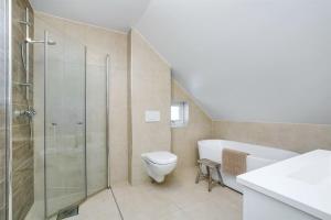 uma casa de banho com um chuveiro, um WC e um lavatório. em Hygge houses I Apartment with panorama view em Lillestrøm
