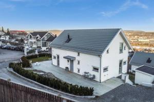 uma casa branca com um telhado preto e um parque de estacionamento em Hygge houses I Apartment with panorama view em Lillestrøm