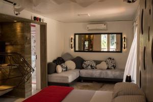 ein Wohnzimmer mit einem Sofa und einem Spiegel in der Unterkunft Pousada Vila do Mel in Pontal do Paraná