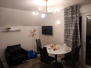 a dining room with a table and chairs and a chandelier at Appartement Cosy proche Colmar in Andolsheim