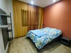 ein kleines Schlafzimmer mit einem Bett mit einer blauen Decke in der Unterkunft luxury house with garden view close to beach in Casablanca
