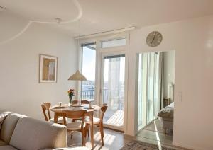 a living room with a dining room table and a clock at Hostit Arctic Apartments in Rovaniemi