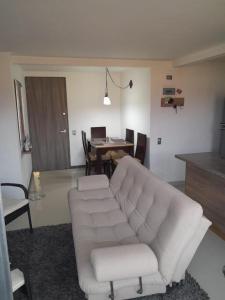 a living room with a white couch and a table at Apartamento inigualable en la ciudad de Medellín excelente vista piso 25 in Medellín