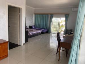 een slaapkamer met een bed, een bureau en een tafel bij Dupincia Lodge in Nuku‘alofa