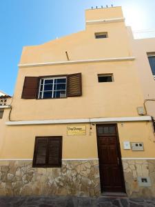 a building with two windows and a door at Daydream Medano Coliving in El Médano