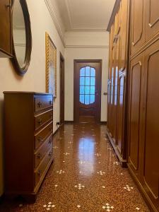 um corredor com uma cómoda, um espelho e uma porta em LEONE VACANZE em Génova