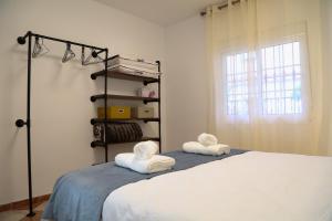 a bedroom with a bed with towels on it at Casa Centro Fuengirola Gran Patio in Fuengirola