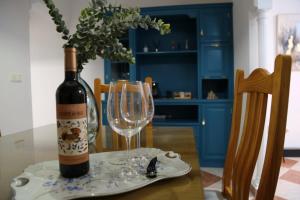 a bottle of wine and a wine glass on a table at Casa Centro Fuengirola Gran Patio in Fuengirola +21 photos