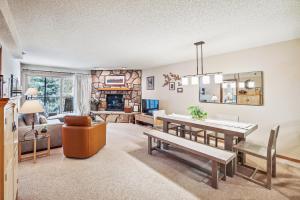 a living room with a table and a fireplace at Atrium 106 in Breckenridge