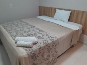 a bed with two towels sitting on top of it at LC Palace Hotel in Capim Grosso